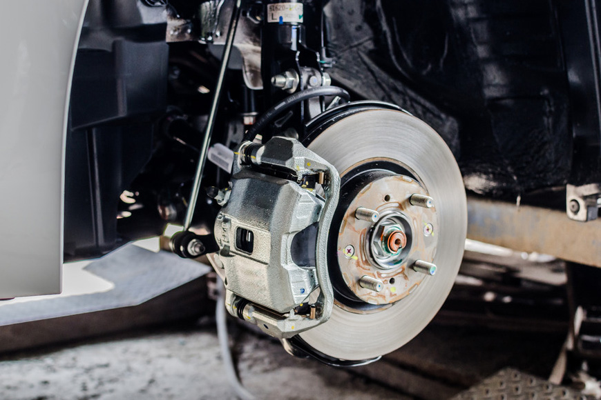 A technician carrying out brake repairs in a garage workshop